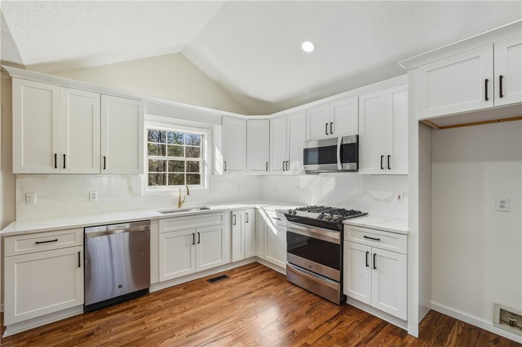 615 Amberwood Place Euharlee, GA 30145 - Photo 5 of 37 a kitchen with granite countertop stainless steel appliances cabinets and wooden floor