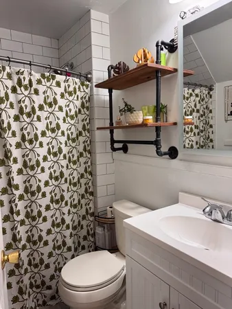 a bathroom with a toilet and a shower curtain