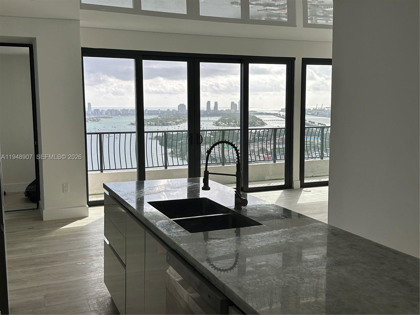 555 Northeast 15th Street, Unit TSA Miami, FL 33132 - Photo 5 of 24 a kitchen with granite countertop a sink and a window