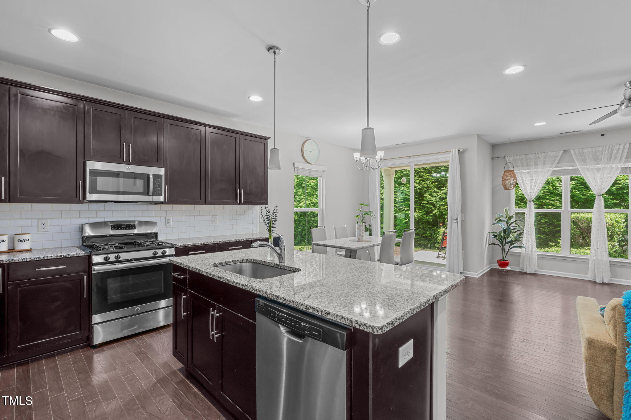 157 Writing Rock Place Apex, NC 27539 - Photo 5 of 28 a kitchen with stainless steel appliances granite countertop a stove a sink and a refrigerator