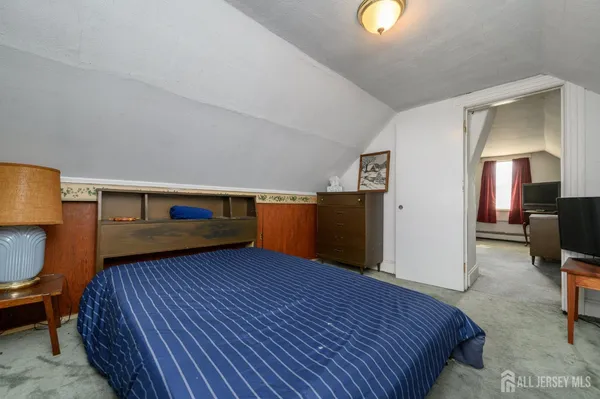 a bed room with a bed and a television