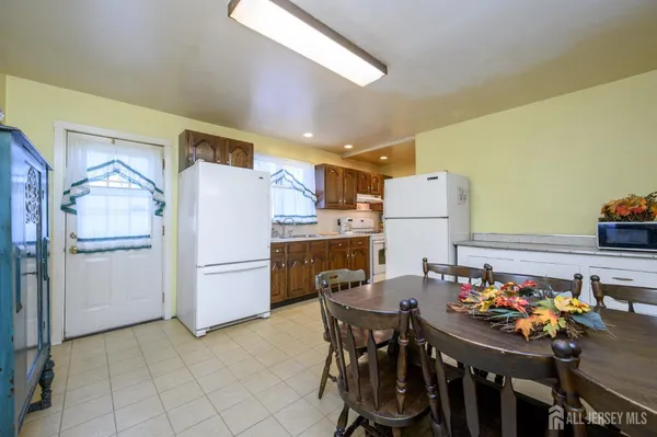 a kitchen with a refrigerator and table chairs
