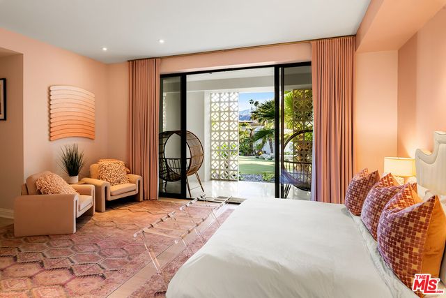 a bedroom with a bed lamp and a potted plant
