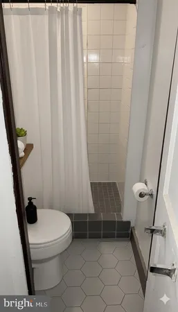 a bathroom with a toilet and a shower curtain