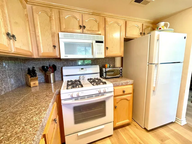 a kitchen with a white stove and refrigerator
