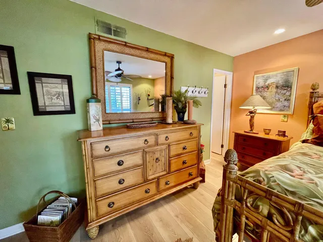 a bedroom with a bed and a mirror on the dresser