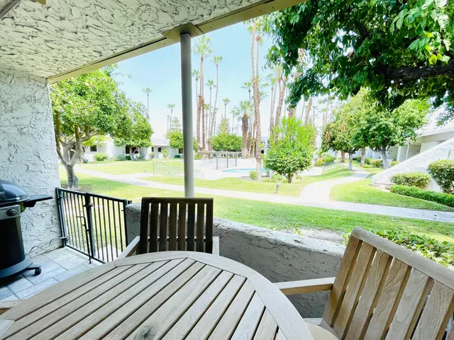 a view of a deck with a chair and floor to ceiling window