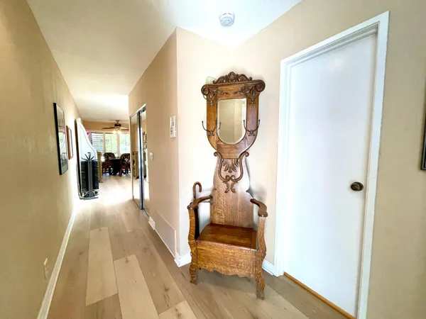 a view of a hallway with wooden floor and a mirror