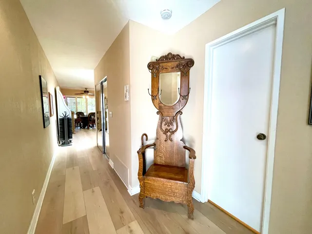 a view of a hallway with wooden floor and a mirror