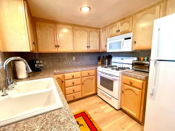 a kitchen with stainless steel appliances a stove a sink and a refrigerator