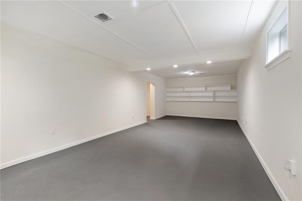 157 Wildwood Road Midland, PA 15059 - Photo 14 of 25 Large, walkout game room area with built-in shelves on far wall.