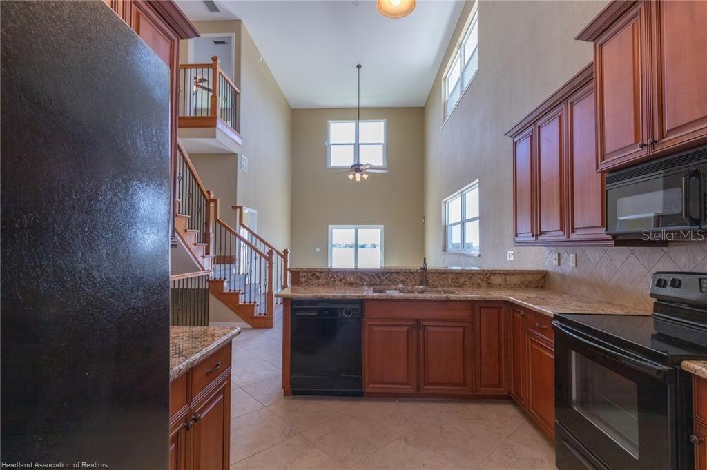 1900 Oasis Boulevard Sebring, FL 33870 - Photo 14 of 18 a kitchen with stainless steel appliances granite countertop a stove and a sink