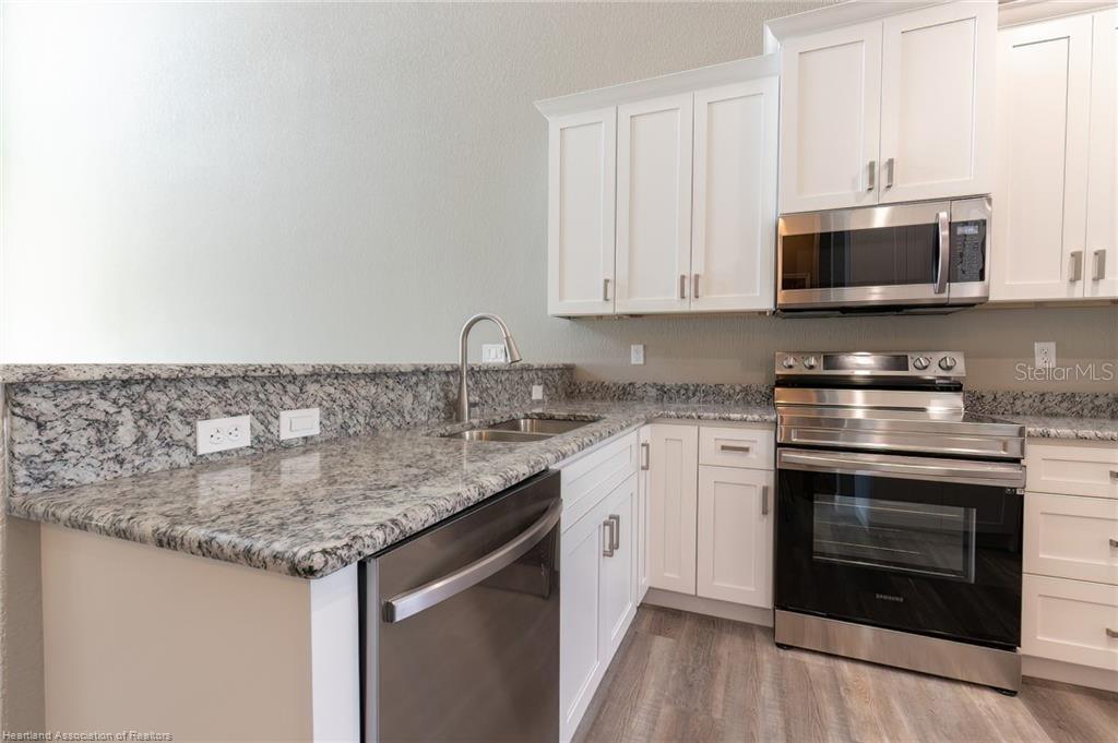 1900 Oasis Boulevard Sebring, FL 33870 - Photo 10 of 18 a kitchen with stainless steel appliances granite countertop a stove and a sink