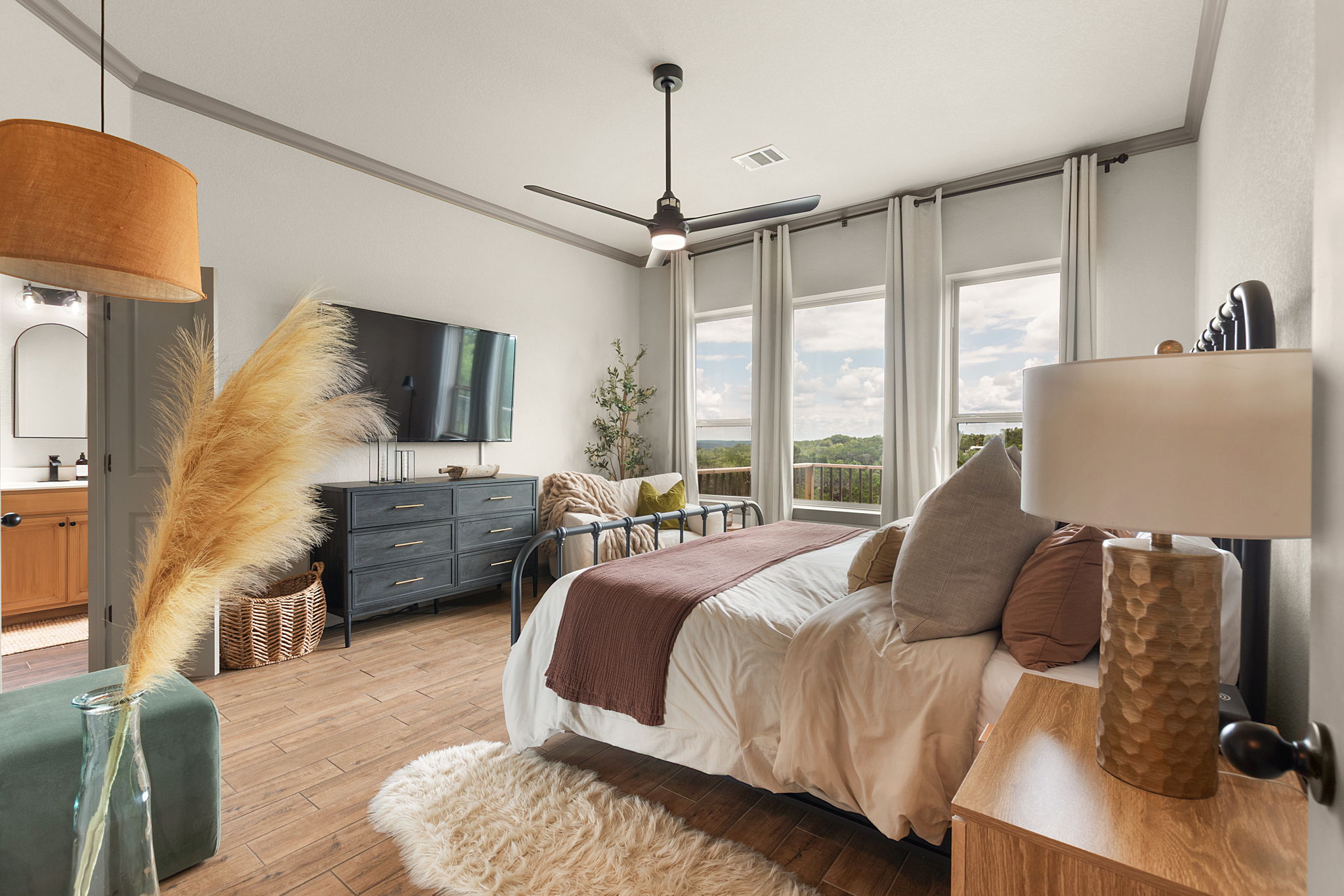 155 Balcones Ridge Way Bertram, TX 78605 - Photo 25 of 37 Relax and unwind in the primary bedroom featuring large windows and high ceiling.