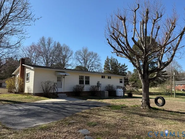 a view of a house with backyard and trees