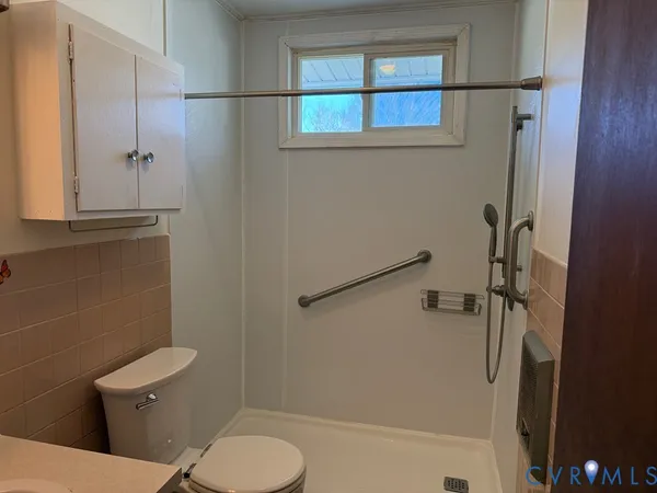a white toilet sitting next to a bathroom sink and tub