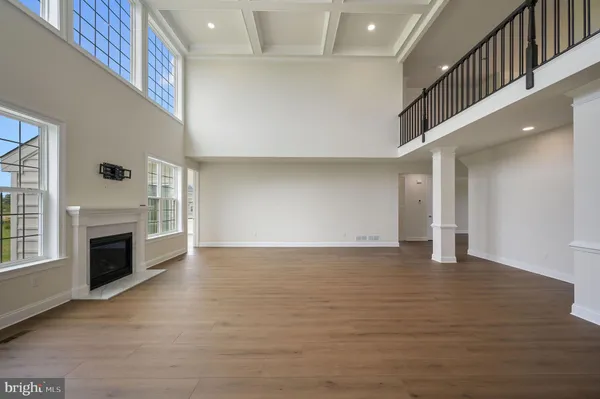 a view of empty room with wooden floor and fireplace