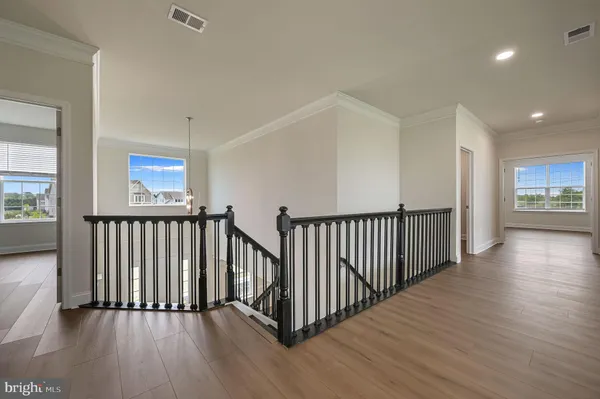 a view of a hallway with wooden floor and windows