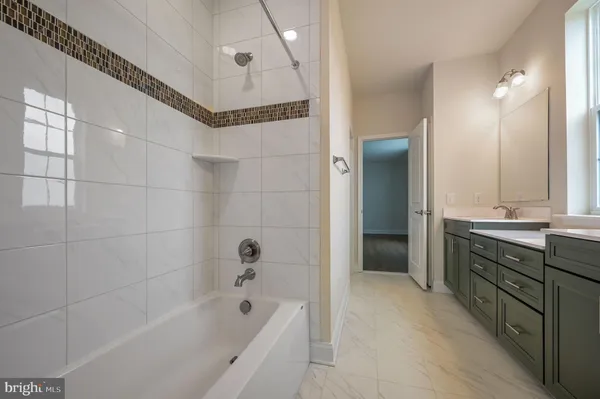a bathroom with a tub a sink and a mirror