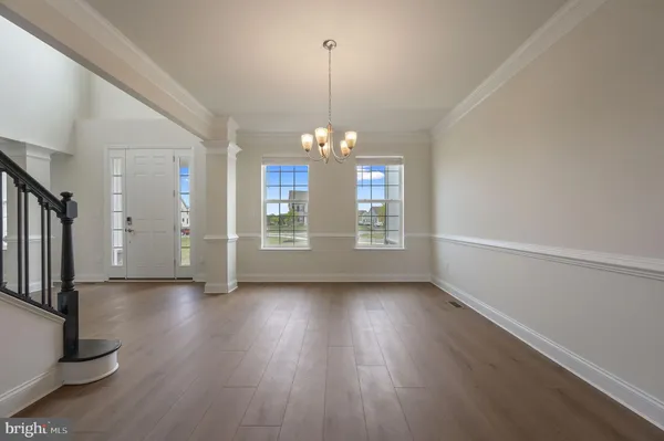 a view of a room with window wooden floor and front door