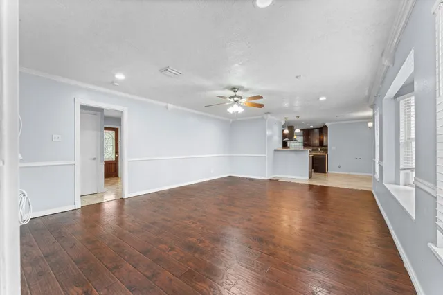 a view of empty room with wooden floor