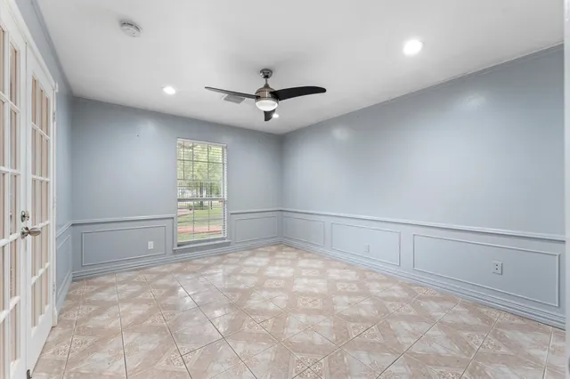 en empty room with windows and ceiling fan