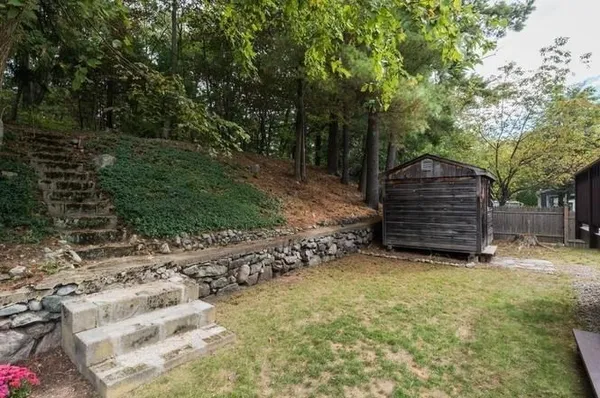 a view of a wooden house with large trees