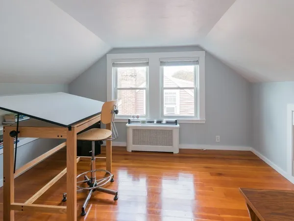 an empty room with a window and wooden floor