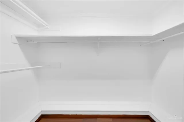 an empty room with a window and a ceiling fan