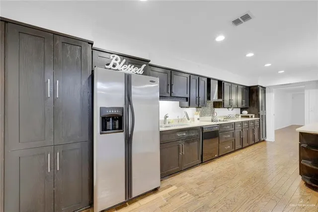 a kitchen with stainless steel appliances granite countertop a refrigerator and a sink