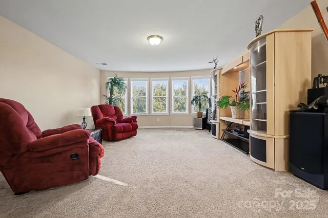 a living room with furniture a flat screen tv and large windows