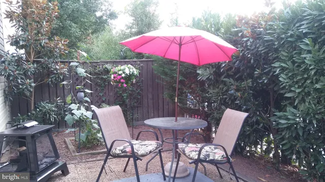 a patio with a table and chairs under an umbrella