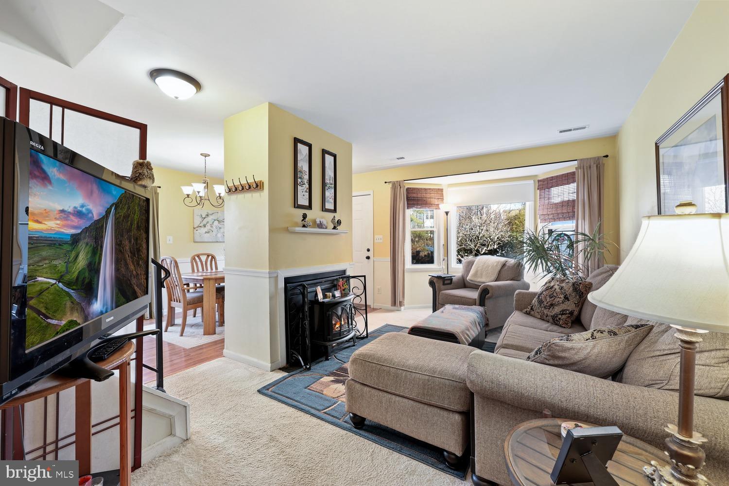 6029 Sunset Ridge Court Centreville, VA 20121 - Photo 2 of 31 a living room with furniture a flat screen tv and a floor to ceiling window