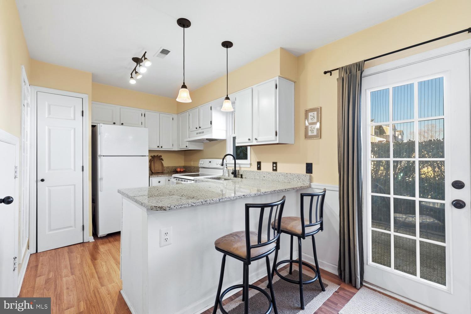6029 Sunset Ridge Court Centreville, VA 20121 - Photo 5 of 31 a kitchen with kitchen island a dining table chairs and white cabinets