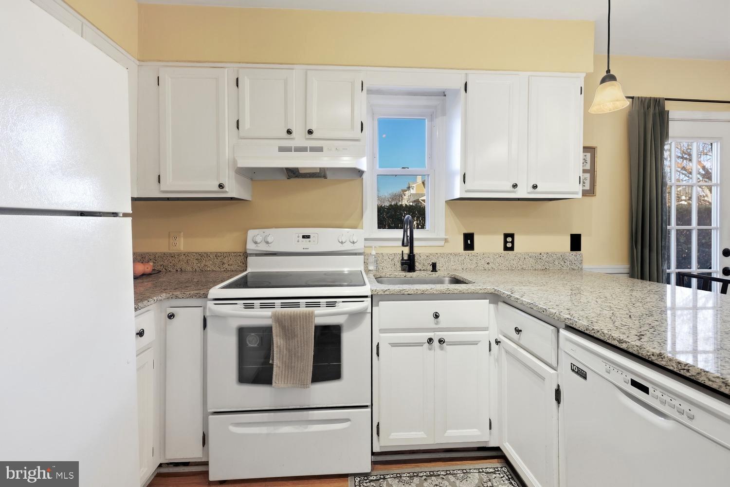 6029 Sunset Ridge Court Centreville, VA 20121 - Photo 7 of 31 a kitchen with granite countertop white cabinets and white appliances