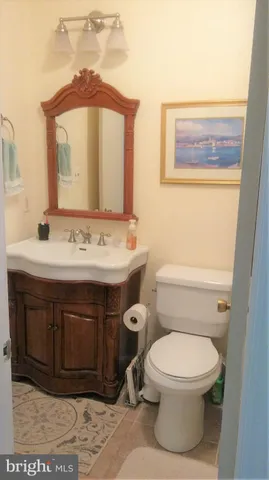a bathroom with a toilet a sink and mirror