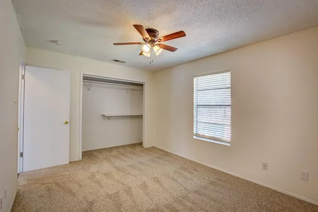 a view of a livingroom with a ceiling fan and window
