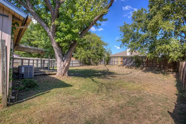 a view of a house with backyard and tree
