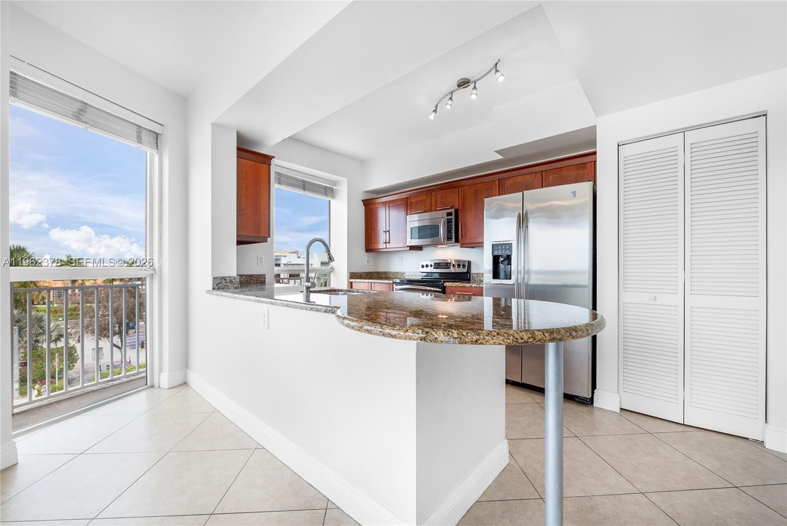 7270 Southwest 88th Street, Unit B303 Miami, FL 33156 - Photo 4 of 15 a kitchen with stainless steel appliances granite countertop a refrigerator and a sink