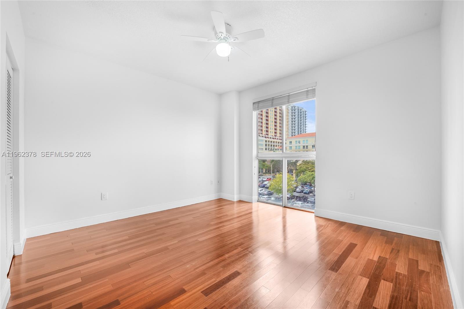 7270 Southwest 88th Street, Unit B303 Miami, FL 33156 - Photo 7 of 15 wooden floor in an empty room with a window