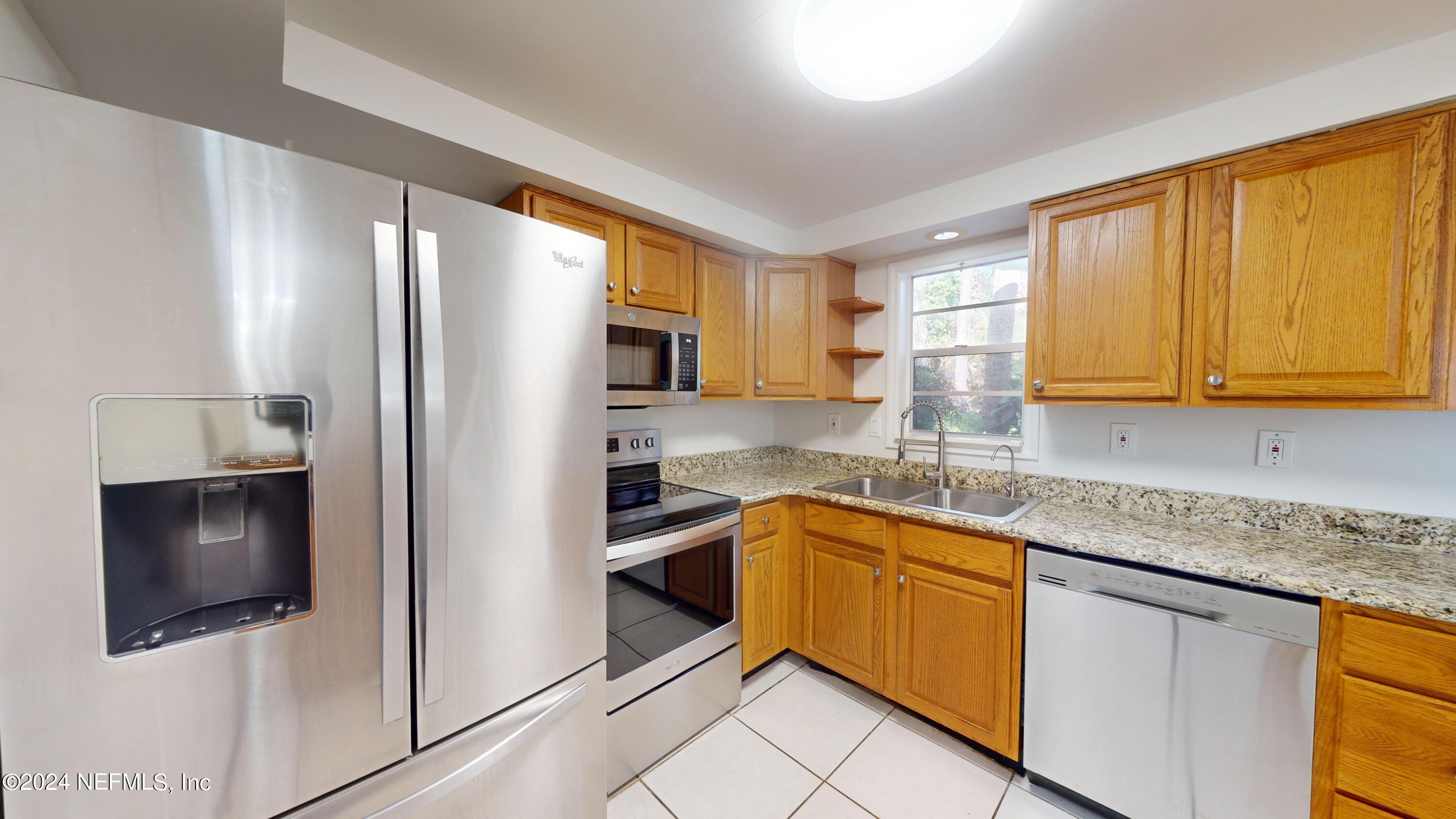 a kitchen with stainless steel appliances granite countertop a refrigerator sink and microwave