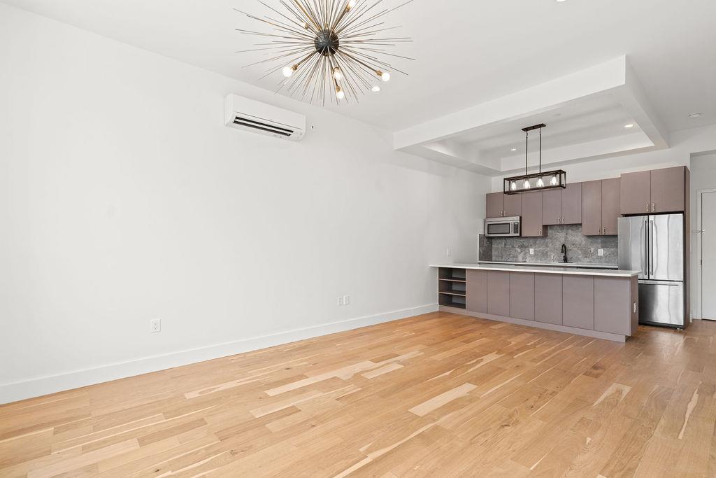 5-12 51st Avenue, Unit 2A Queens, NY 11101 - Photo 2 of 8 a kitchen with stainless steel appliances a refrigerator and a stove top oven