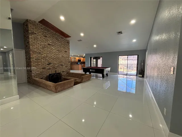 a living room with patio furniture and a fireplace