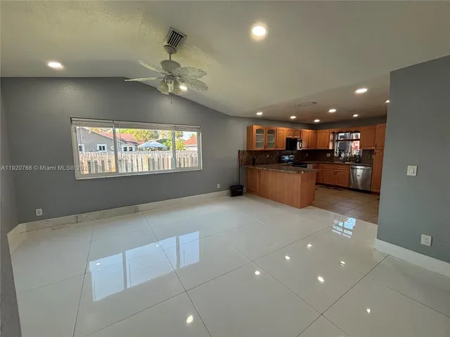 a open kitchen with stainless steel appliances granite countertop a large stove a sink and a refrigerator