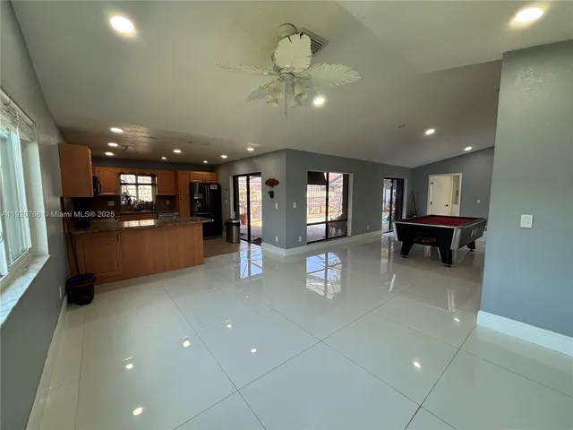 a view of a living room and kitchen with a refrigerator a microwave oven