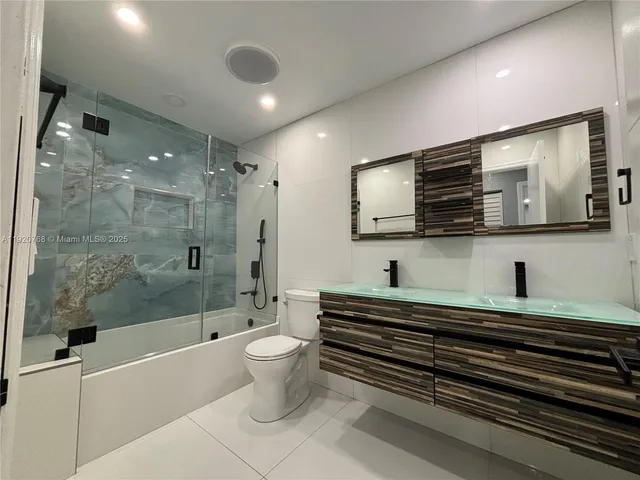 a spacious bathroom with a bathtub shower sink mirror and toilet