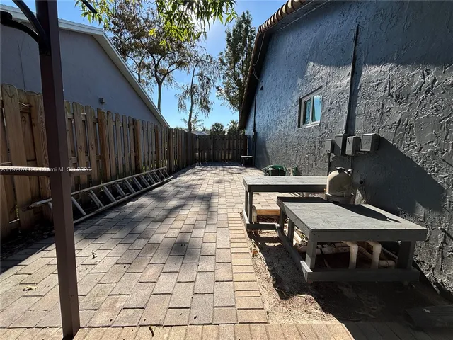 a view of a patio with table and chairs with wooden fence and plants