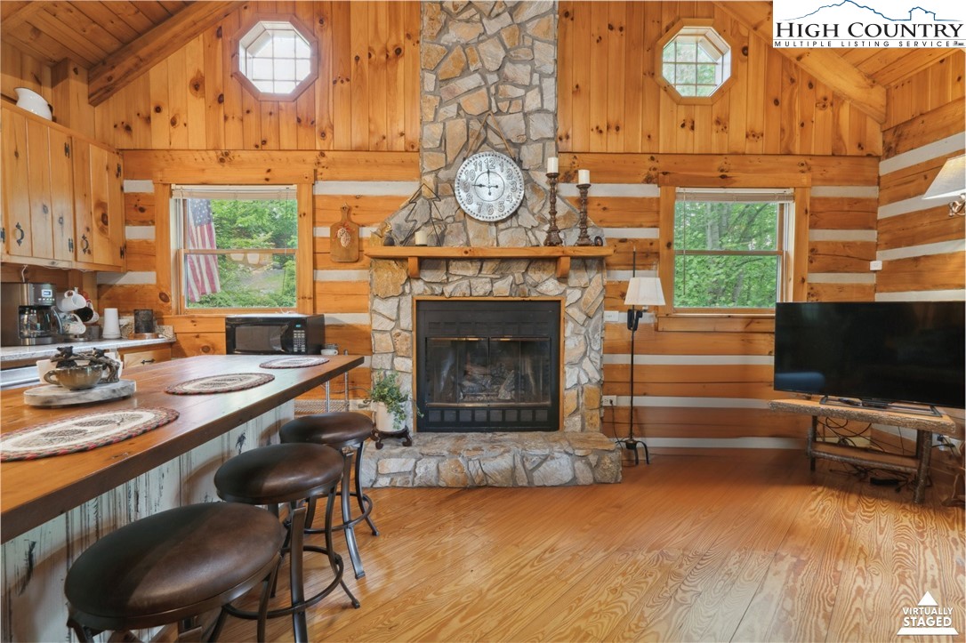 710 River Hills Road Lansing, NC 28643 - Photo 14 of 38 a living room with furniture a fireplace and a flat screen tv