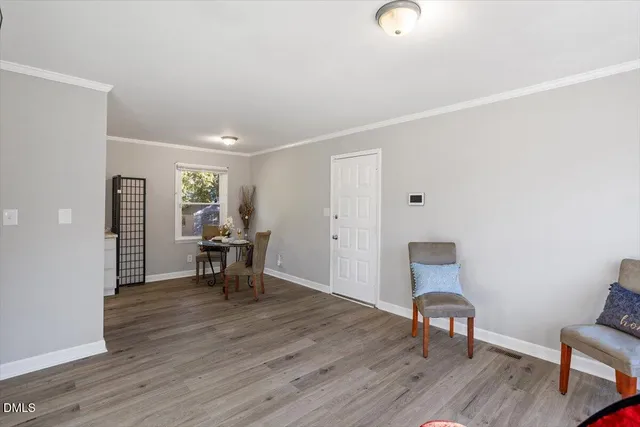 a view of a room with wooden floor lounge chair and windows