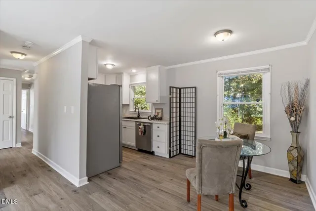 a kitchen with a refrigerator and a table chair